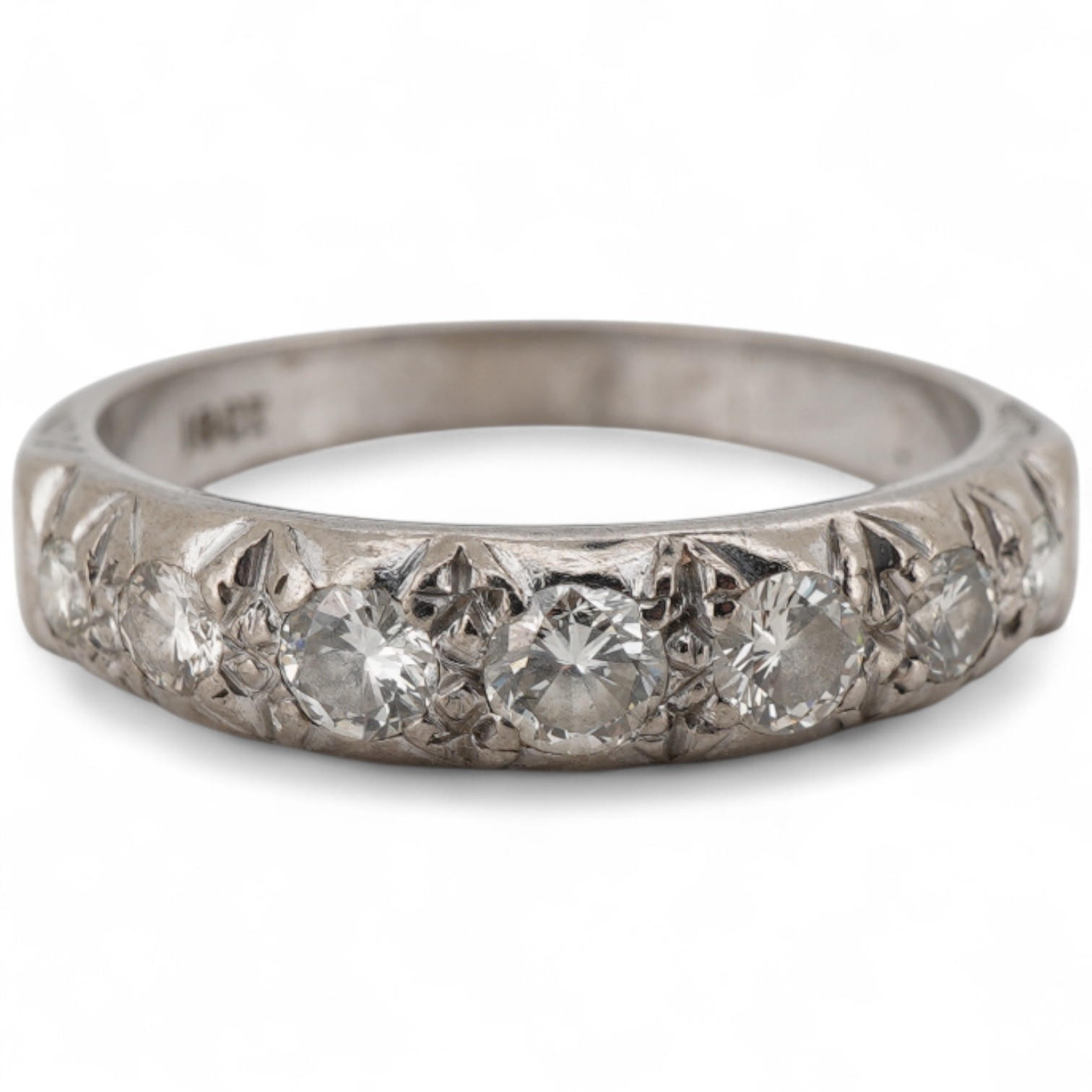 A white metal, (stamped 18ct) and graduated seven stone diamond set half hoop ring, size M.